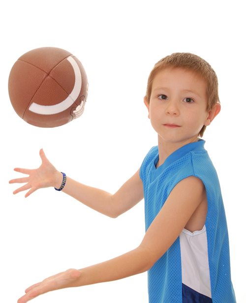 Boy wearing silicone wristband playing football