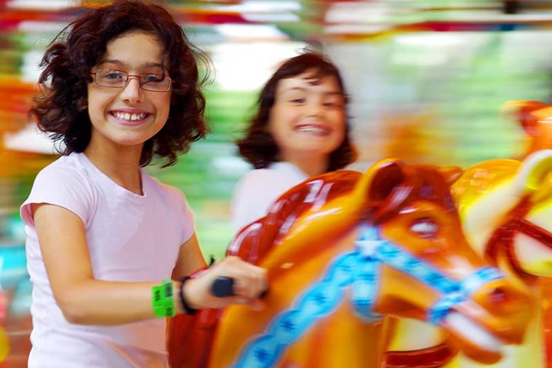 Girls wearing vinyl wristbands on carousel