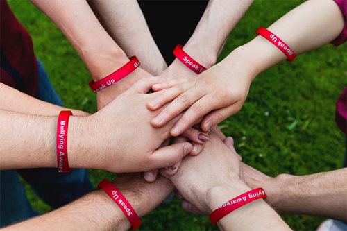 Hands wearing anti-bullying wristbands