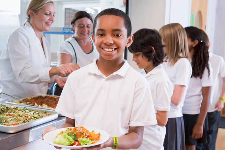 Boy in lunch line wearing Tyvek wristband alerting staff of a food allergy